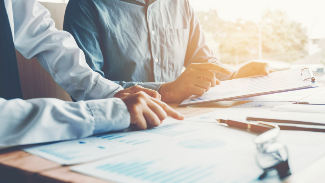 two people incorporating a business with paperwork spread out on a desk