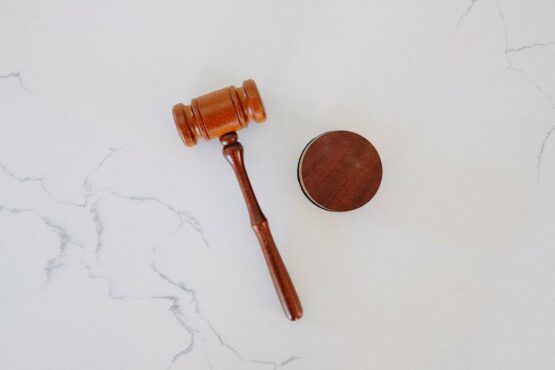 Wooden gavel lying on a white marble surface.