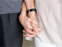 Older couple holding hands.