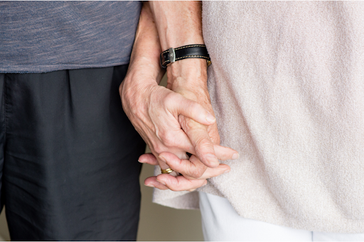 Older couple holding hands.