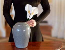 Woman with Cremation Urn at Funeral.