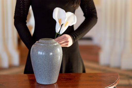 Woman with Cremation Urn at Funeral.