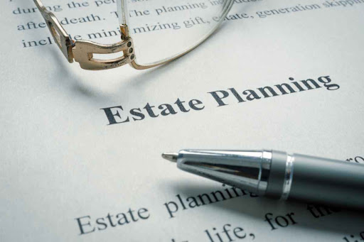 Glasses and pen laid across an estate planning document.