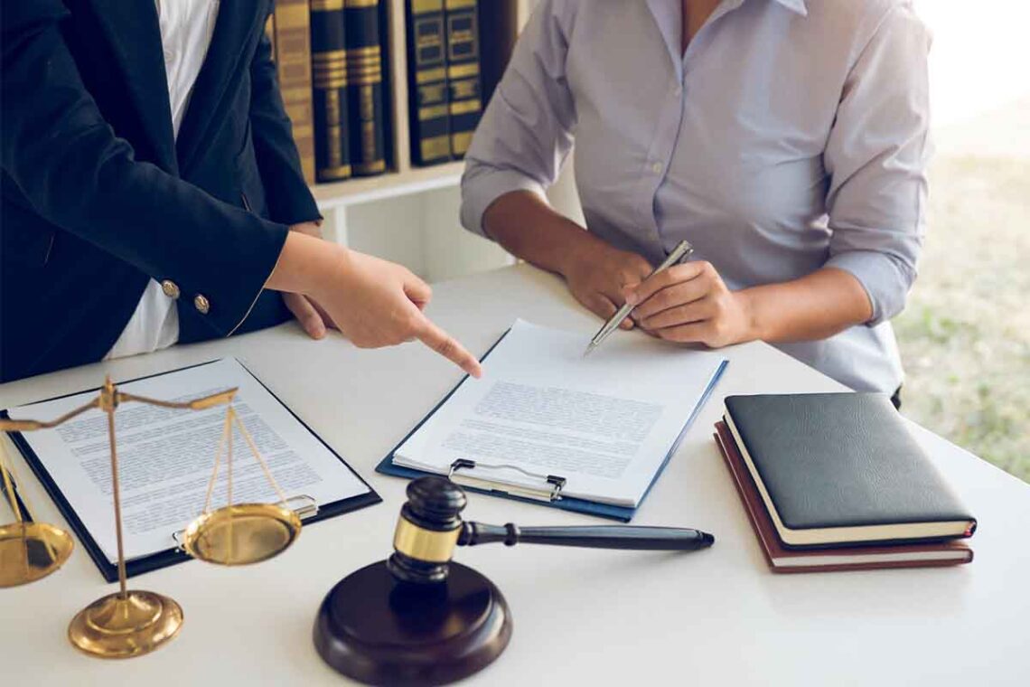 Lawyer pointing at a document their client is signing
